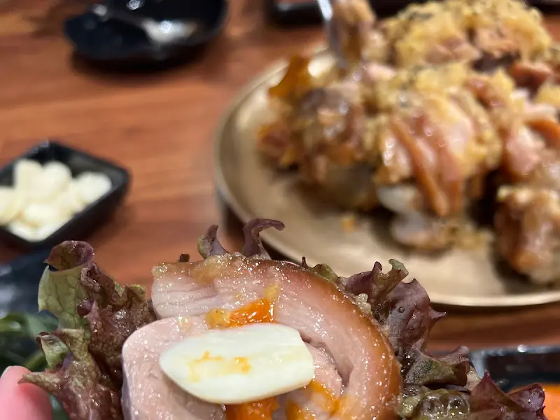 족발에 마늘을 올려 쌈을 싸 먹는 모습