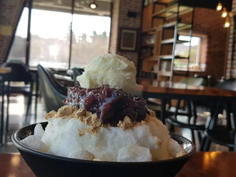 팥빙수 위에 팥과 떡, 콩가루가 듬뿍 올려진 모습