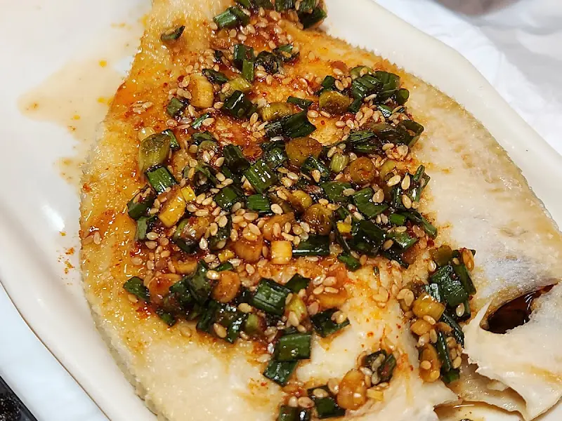 윤기가 흐르는 꼬막 요리의 클로즈업 사진. 신선함이 느껴진다.