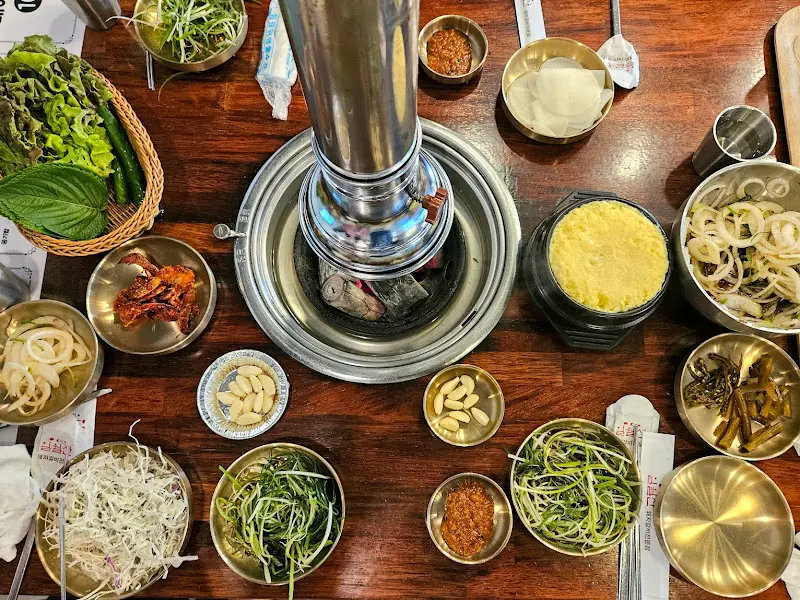 숯불과 함께 다양한 밑반찬이 놓인 테이블