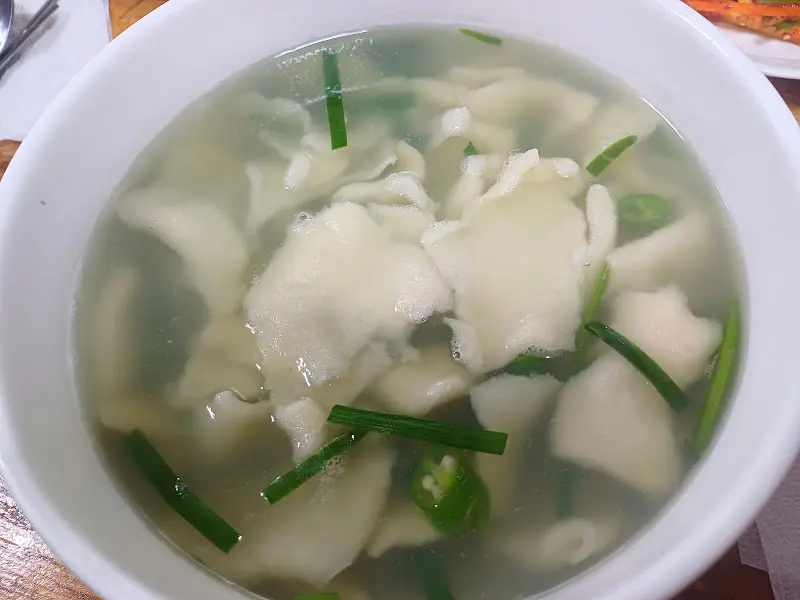 뽀얀 국물에 수제비와 다슬기가 담겨 있다.