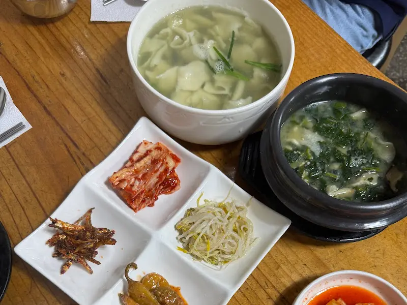 다슬기 수제비와 토장탕, 밑반찬이 차려진 테이블 전경.