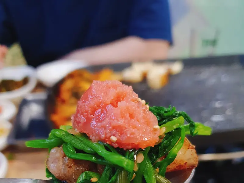 구운 돼지고기 위에 명란젓을 올려놓은 모습