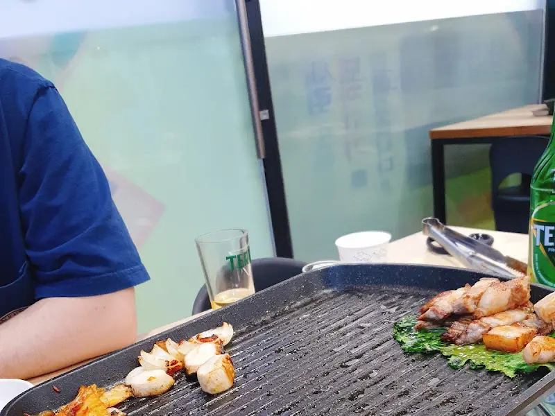 불판 위에서 맛있게 구워지고 있는 돼지고기와 김치