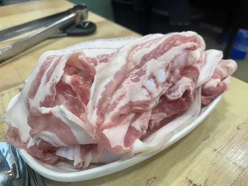 신선한 흙돼지 대패 삼겹살이 접시에 담겨져 있다.