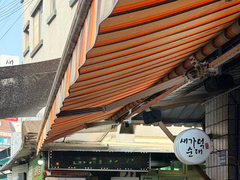 새가덕순대의 외부 모습. 오렌지색과 갈색 스트라이프 어닝이 인상적이다.