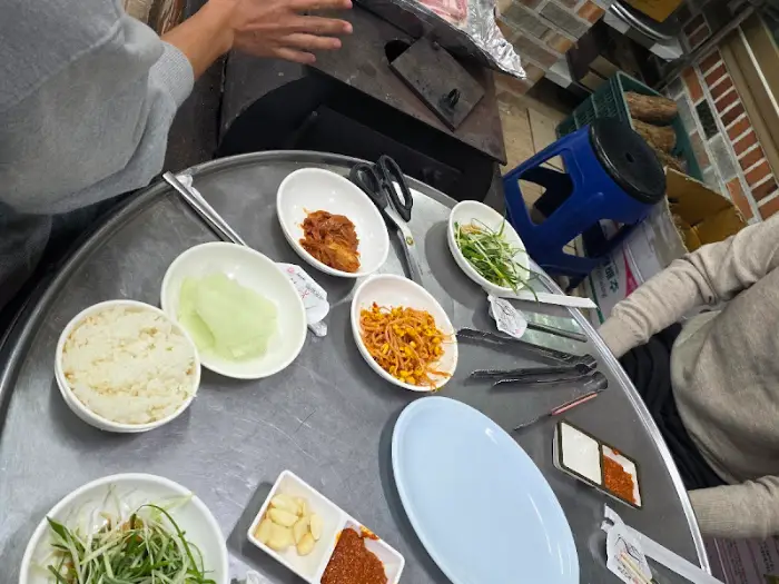 식탁 위에 여러 가지 반찬과 밥, 쌈채소 등이 차려져 있다.
