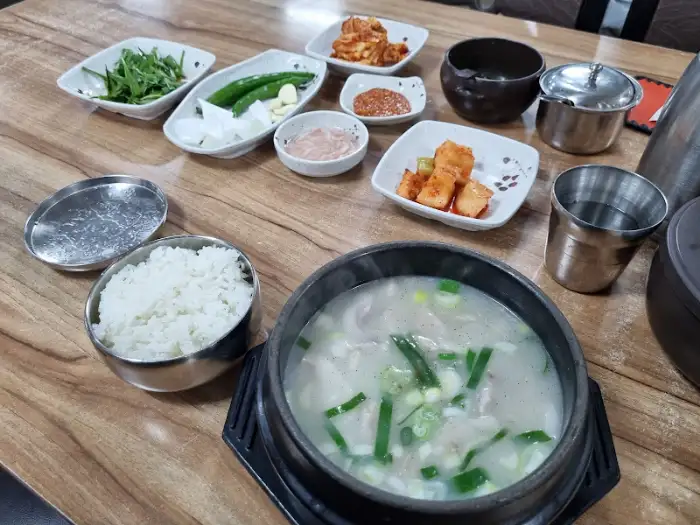 테이블에 차려진 돼지국밥과 다양한 밑반찬, 밥