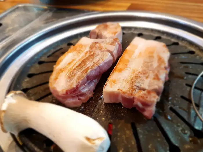 불판 위에서 맛있게 익어가고 있는 삼겹살