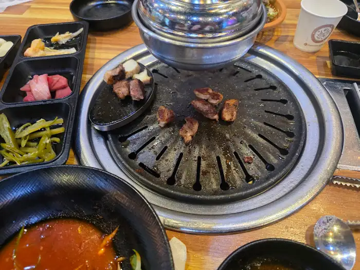 잘 구워진 고기가 불판 위에서 먹음직스럽게 놓여 있는 모습