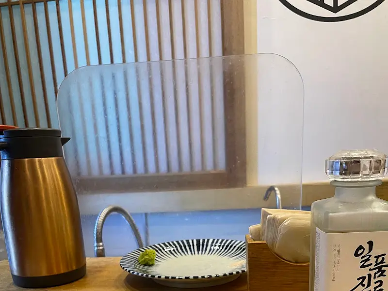 테이블과 투명 가림막, 술병이 놓여진 정갈한 모습