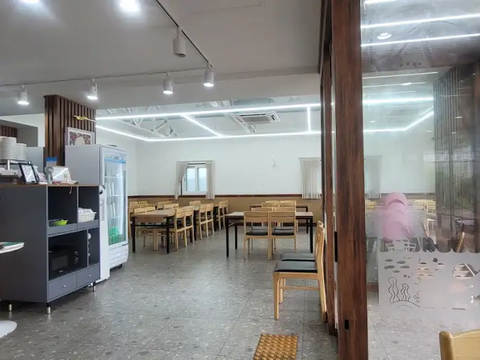 식당 내부, 여러 개의 테이블이 놓여 있고, 벽에는 그림이 걸려 있다.