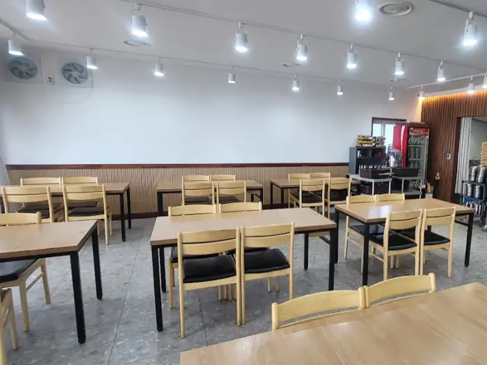식당 내부, 테이블이 여러 개 놓여 있고, 벽면에는 조명이 설치되어 있다.