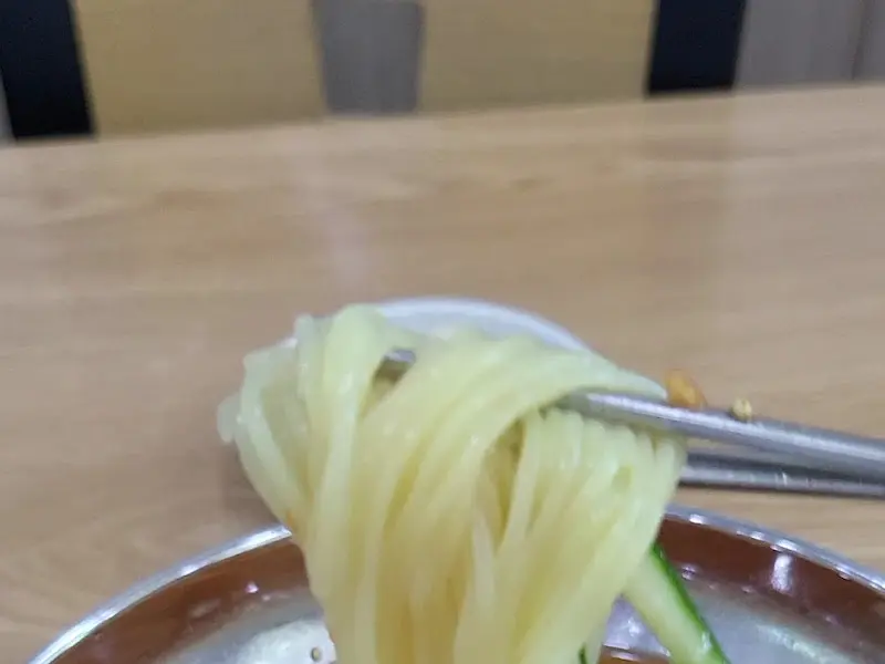 젓가락으로 밀면을 들어올리는 모습