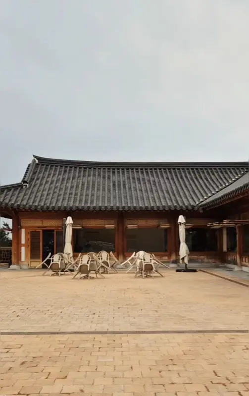 카페 한올 외부 좌석 사진. 파라솔이 설치된 테이블이 놓여 있다.