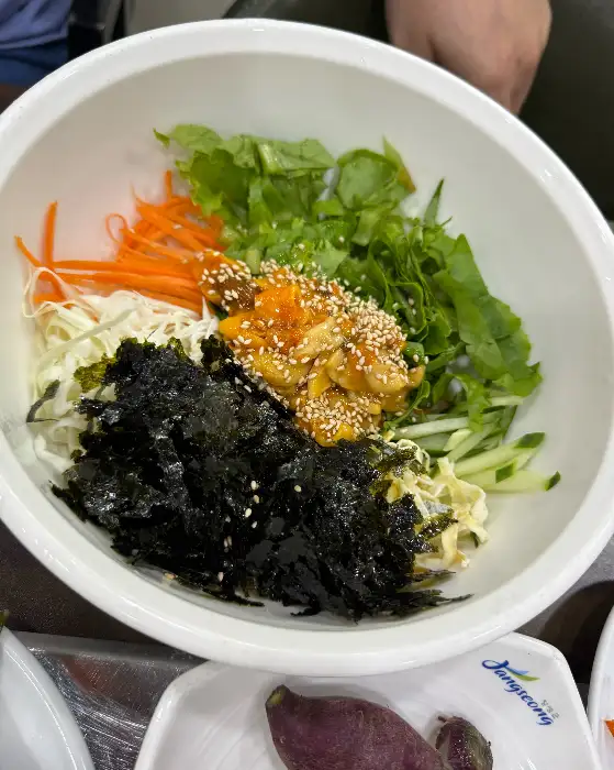 김가루와 신선한 채소, 육회, 콩나물 등이 푸짐하게 담긴 육회비빔밥