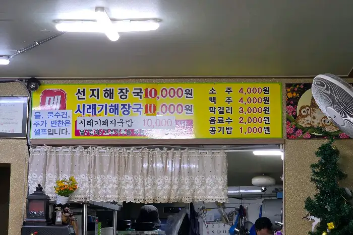 가게 내부 간판에 여러 메뉴와 가격이 적혀 있습니다.