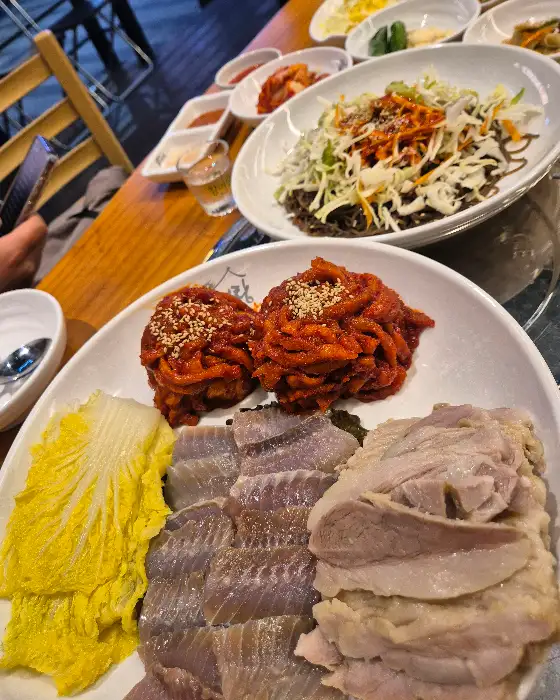 푸짐하게 담긴 보쌈과 쟁반국수, 그리고 여러 반찬들