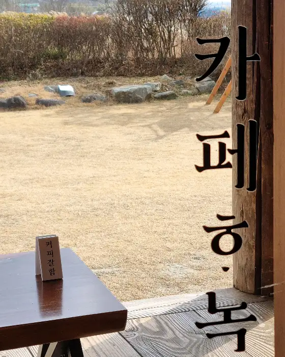 테이블 위에 놓인 작은 나무 표지판과 창밖 풍경