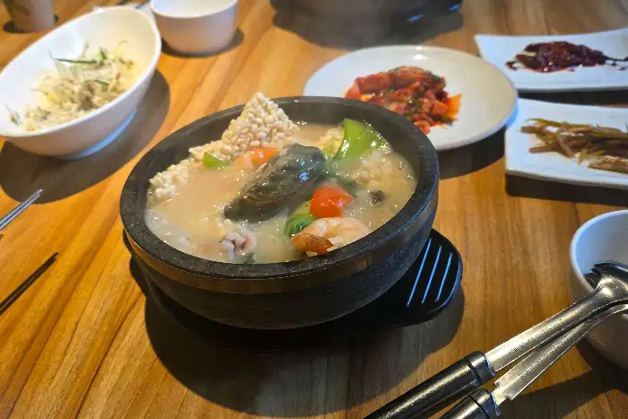 테이블에 차려진 푸짐한 해물누룽지탕과 밑반찬들