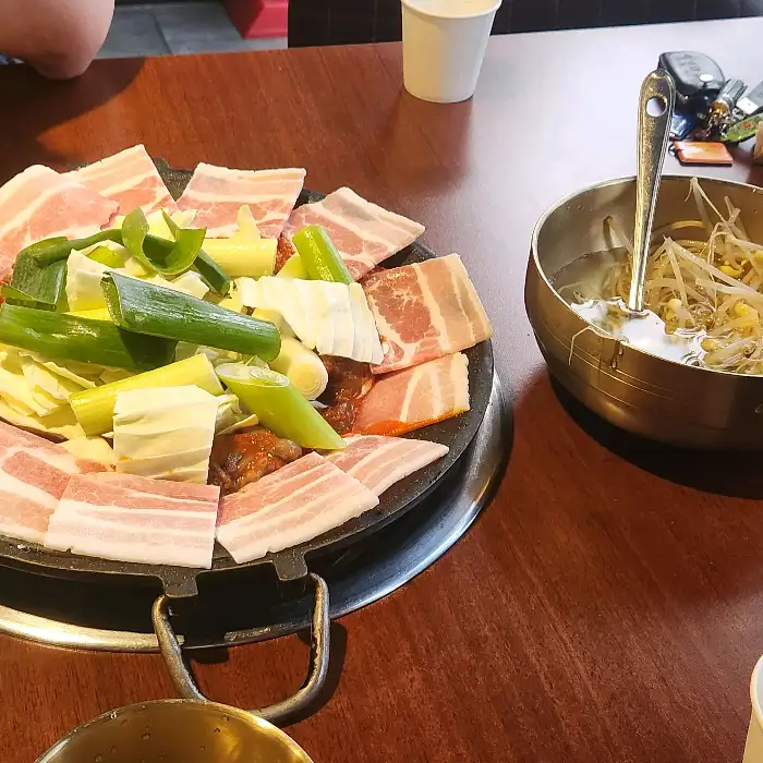 팬에 담겨 나온 쭈꾸미와 삼겹살, 채소의 모습