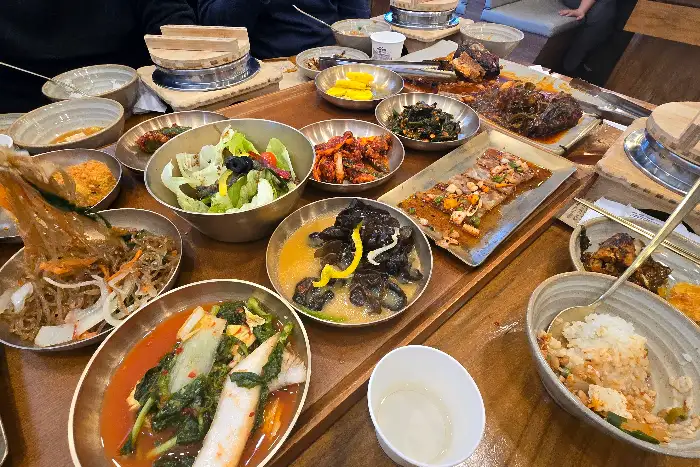 푸짐하게 차려진 한정식 상차림에서 쭈꾸미 볶음 등 메인 요리를 보여주는 모습