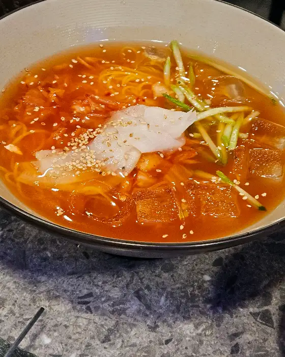 시원한 육수에 면과 고명이 올라간 김치말이 국수