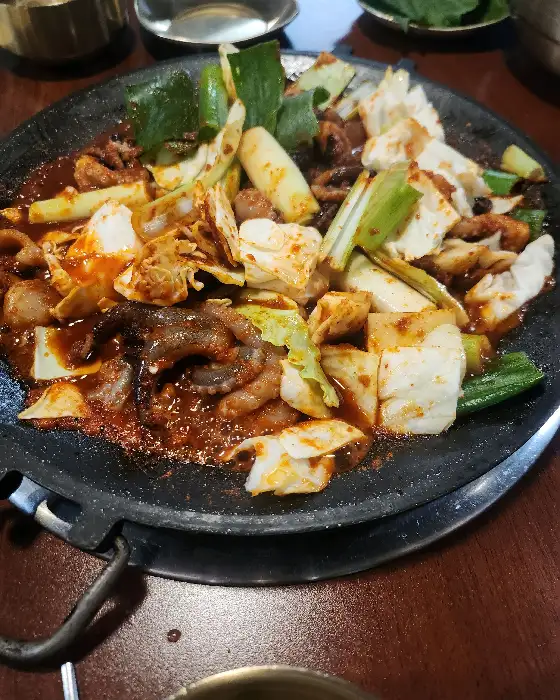 팬 위에서 익어 먹기 좋게 조리된 쭈꾸미와 재료들의 모습