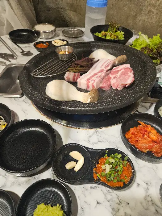 고기, 버섯, 콩나물, 김치 등이 세팅된 불판