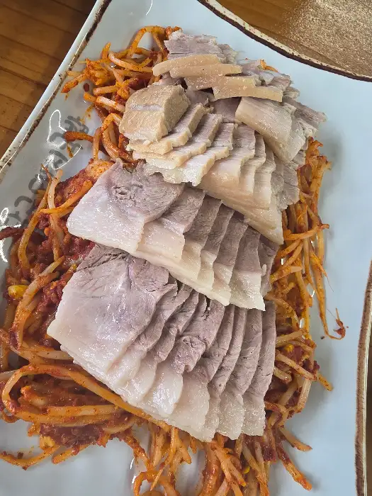수육과 콩나물 무침이 함께 담긴 접시