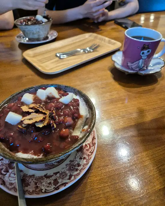 테이블 위에 놓인 팥빙수와 커피잔, 그리고 나무 쟁반