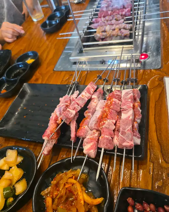 신선한 고기 꼬치들이 접시에 담겨 있는 모습