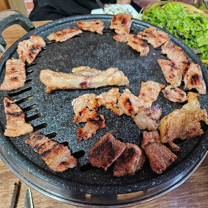 다양한 부위의 갈비가 불판 위에서 구워지고 있는 모습