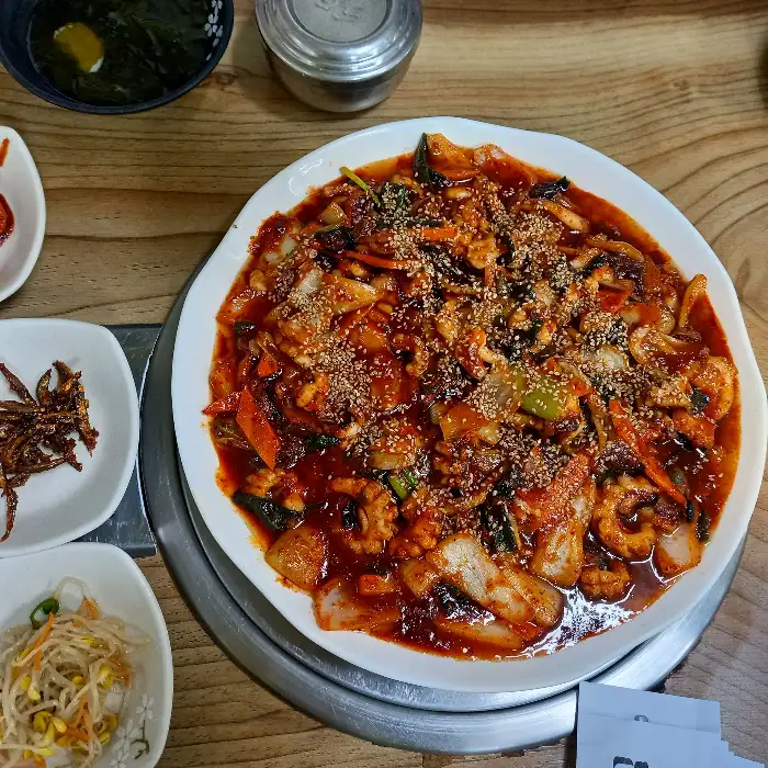 매콤한 양념에 볶아진 갑오징어 요리가 접시에 담겨 있는 모습