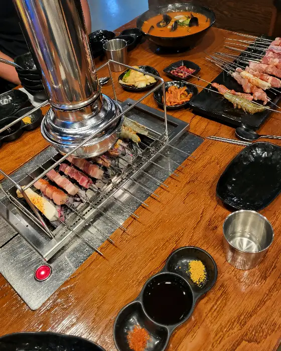 여러 요리가 함께 놓인 테이블 모습, 양꼬치, 탕 등