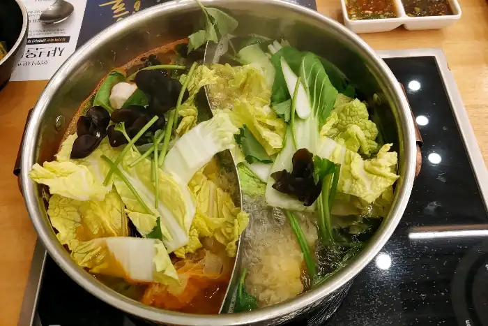 반반 육수 냄비에 채소를 넣어 끓이는 모습