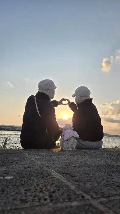 함께 간 일행과 석양을 배경으로 하트 모양을 만들고 있는 모습