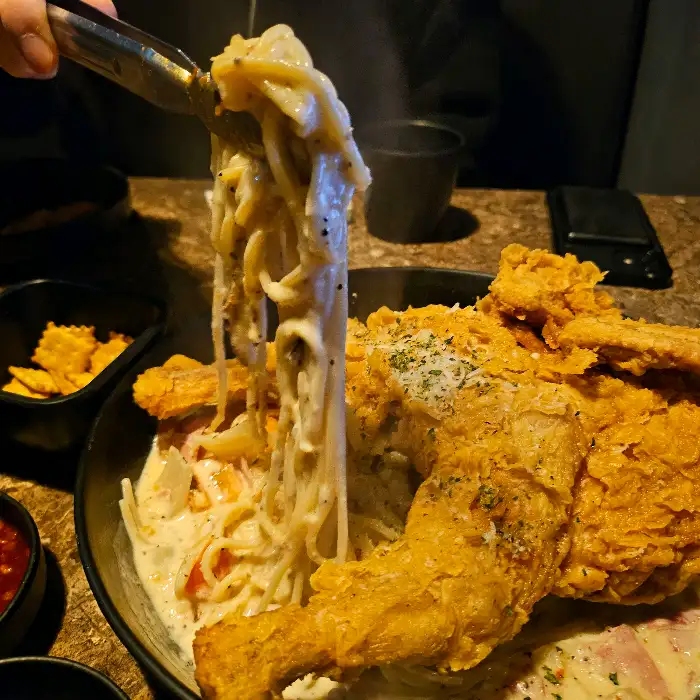 룸 안에서 파스타와 치킨을 즐기는 모습