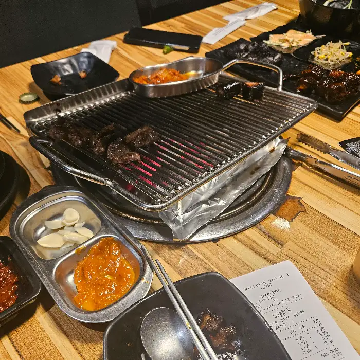낭만돼지 내부 테이블에 놓인 숯불 구이판과 반찬들