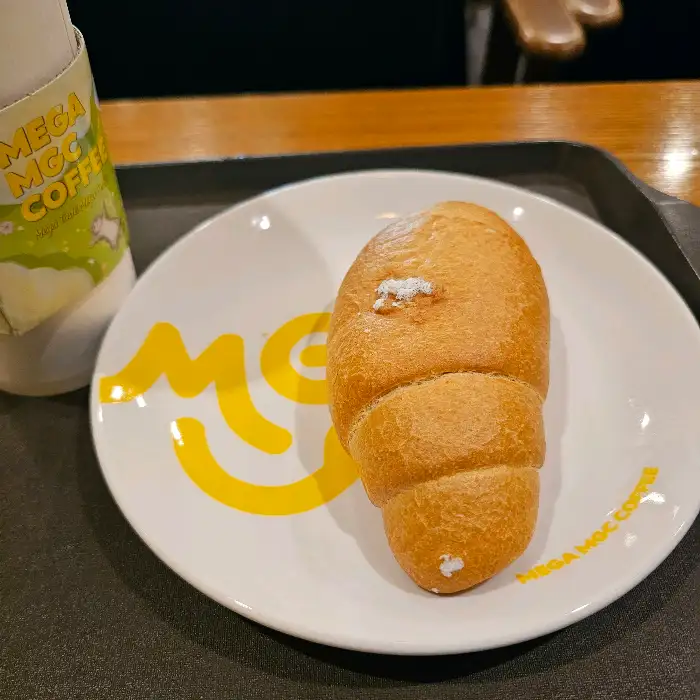 메가커피 로고가 새겨진 접시에 담긴 빵.