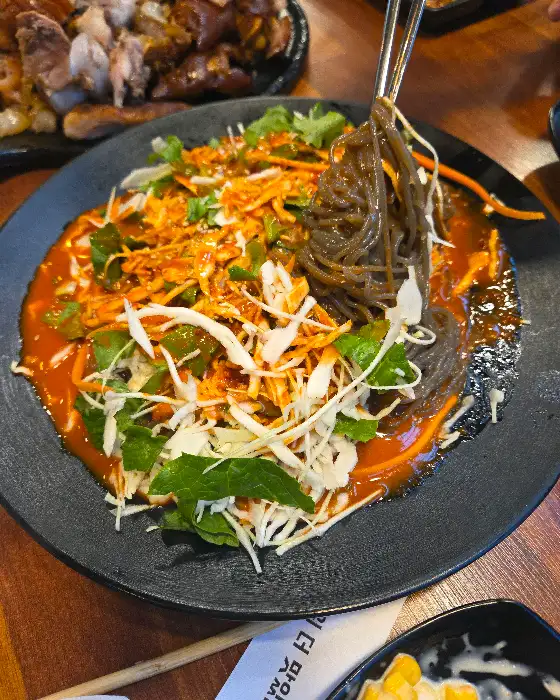 쟁반막국수 면발을 집어 올리는 모습