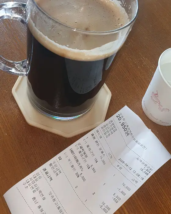 커피잔과 영수증, 그리고 나무 테이블의 모습