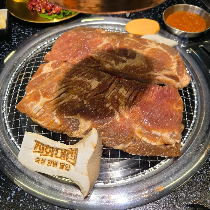 숯불 위에서 구워지는 두툼한 고기
