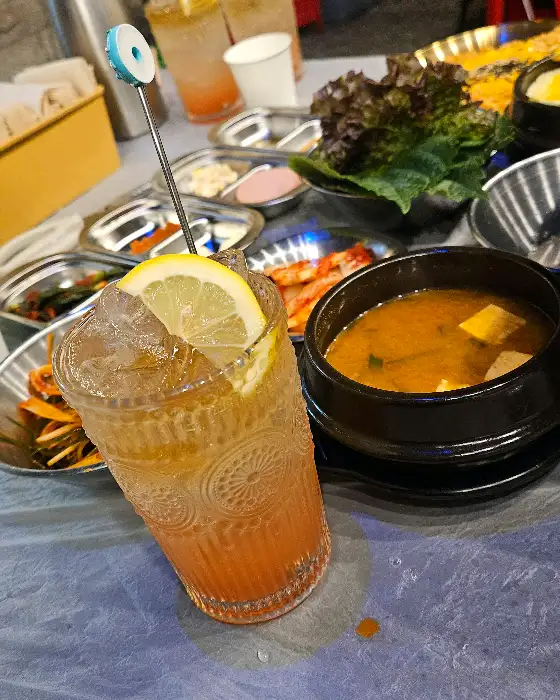 레몬이 띄워진 시원한 음료수와 찌개 모습