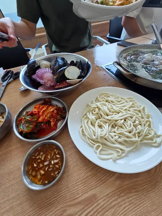 큰 냄비에 담겨 나온 신선한 해물과 칼국수