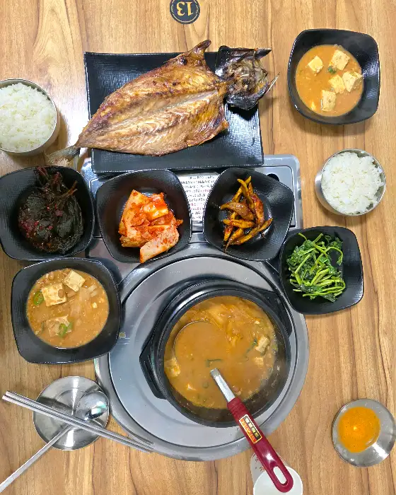 청국장, 고등어구이, 다양한 밑반찬이 정갈하게 차려진 상차림