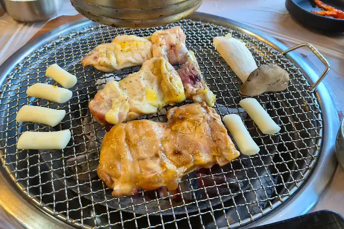 숯불 위에서 구워지는 닭갈비와 떡, 버섯