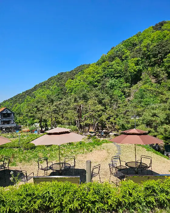 야외 테이블과 우산, 푸른 산 능선
