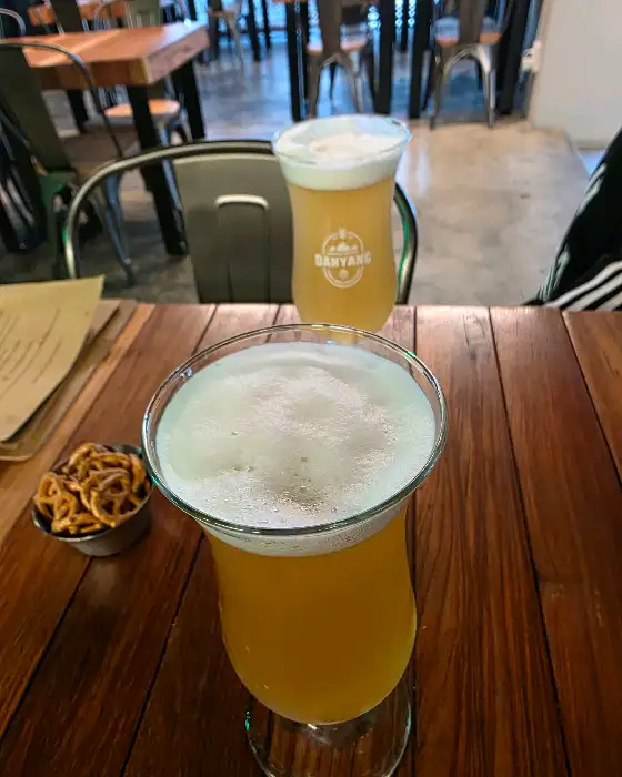 거품이 풍성한 맥주 잔과 옆에 놓인 작은 그릇의 프레첼