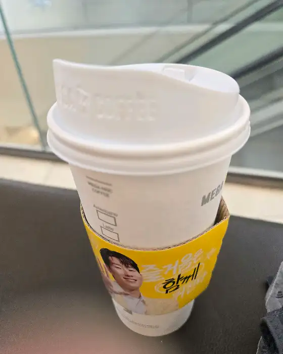 메가커피 로고가 새겨진 컵과 홀더
